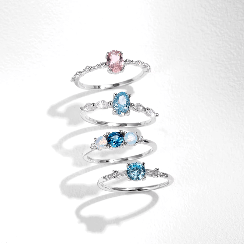 Colorful 925 sterling silver gemstone rings with heart, round, and baguette stones, worn in combination or shown individually
