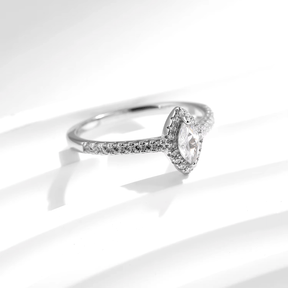 Sterling silver ring with marquise-cut zirconia centerpiece and pavé band, photographed in elegant settings and on hand.