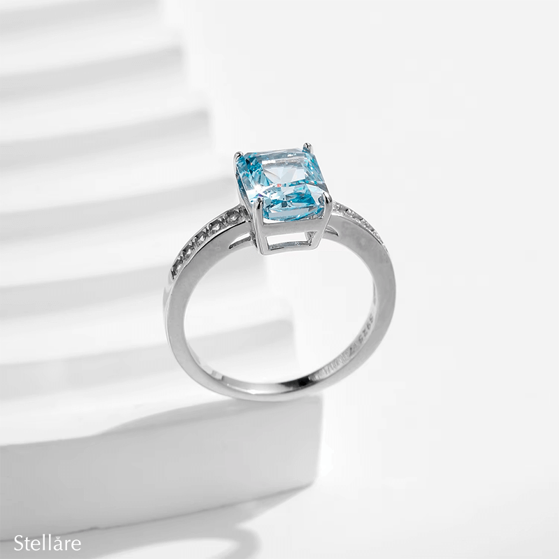 925 sterling silver ring featuring a radiant-cut blue topaz stone with side zirconia accents, shown on hand and in elegant close-up angles