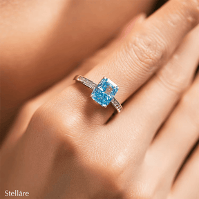 925 sterling silver ring featuring a radiant-cut blue topaz stone with side zirconia accents, shown on hand and in elegant close-up angles