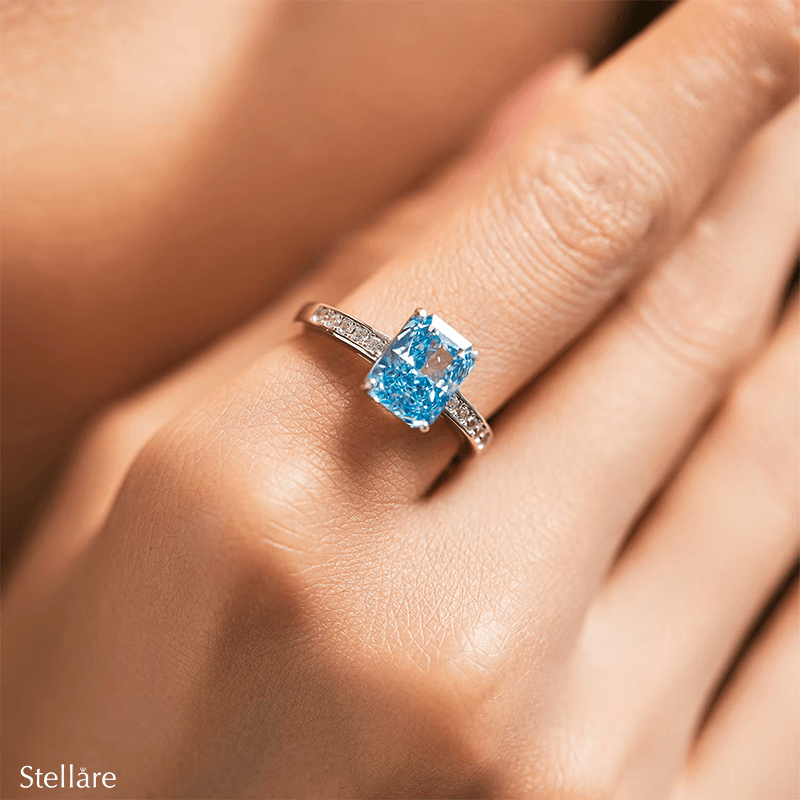 925 sterling silver ring featuring a radiant-cut blue topaz stone with side zirconia accents, shown on hand and in elegant close-up angles