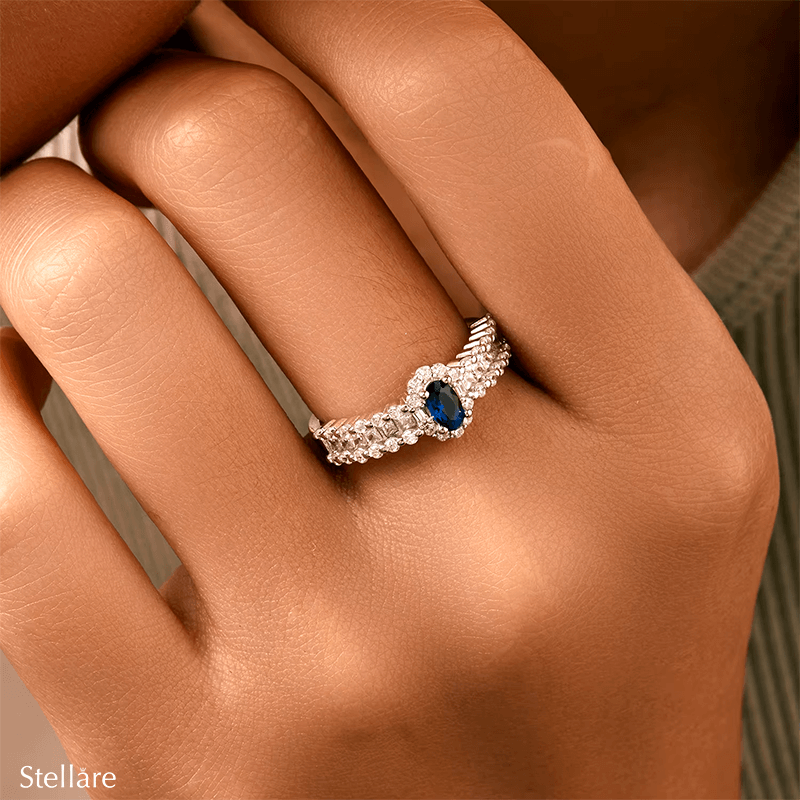 925 sterling silver ring featuring a deep blue oval sapphire and a triple row of shimmering zirconia stones, styled on hand and in detail