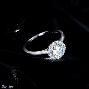 925 sterling silver ring featuring an ocean-blue centre stone encircled by brilliant white zirconia, shown on model and close-up