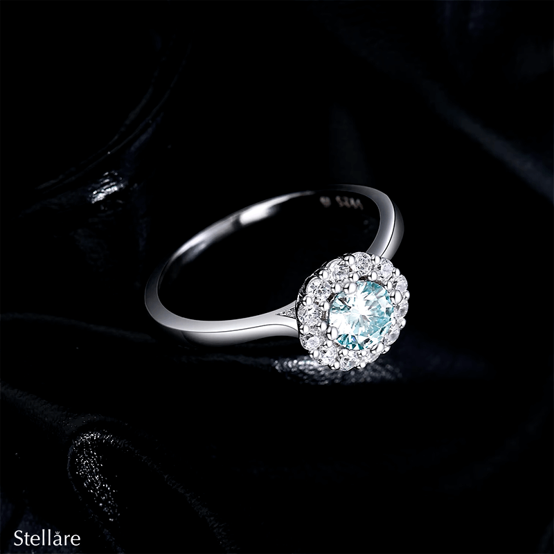 925 sterling silver ring featuring an ocean-blue centre stone encircled by brilliant white zirconia, shown on model and close-up