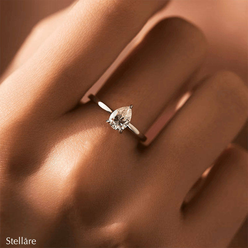 925 silver ring featuring a pear-shaped zirconia stone in a minimalist setting, displayed on hand and in close-up product views
