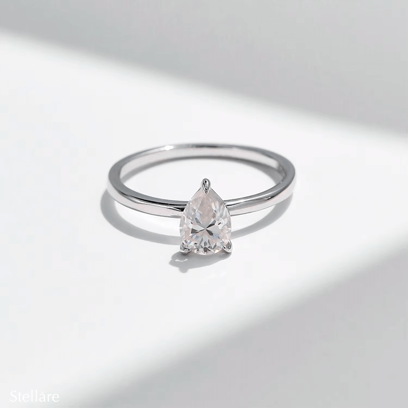 925 silver ring featuring a pear-shaped zirconia stone in a minimalist setting, displayed on hand and in close-up product views