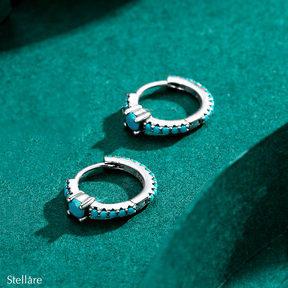 Sterling silver hoop earrings with turquoise stones and central blue charm – elegant and vibrant for stylish everyday wear